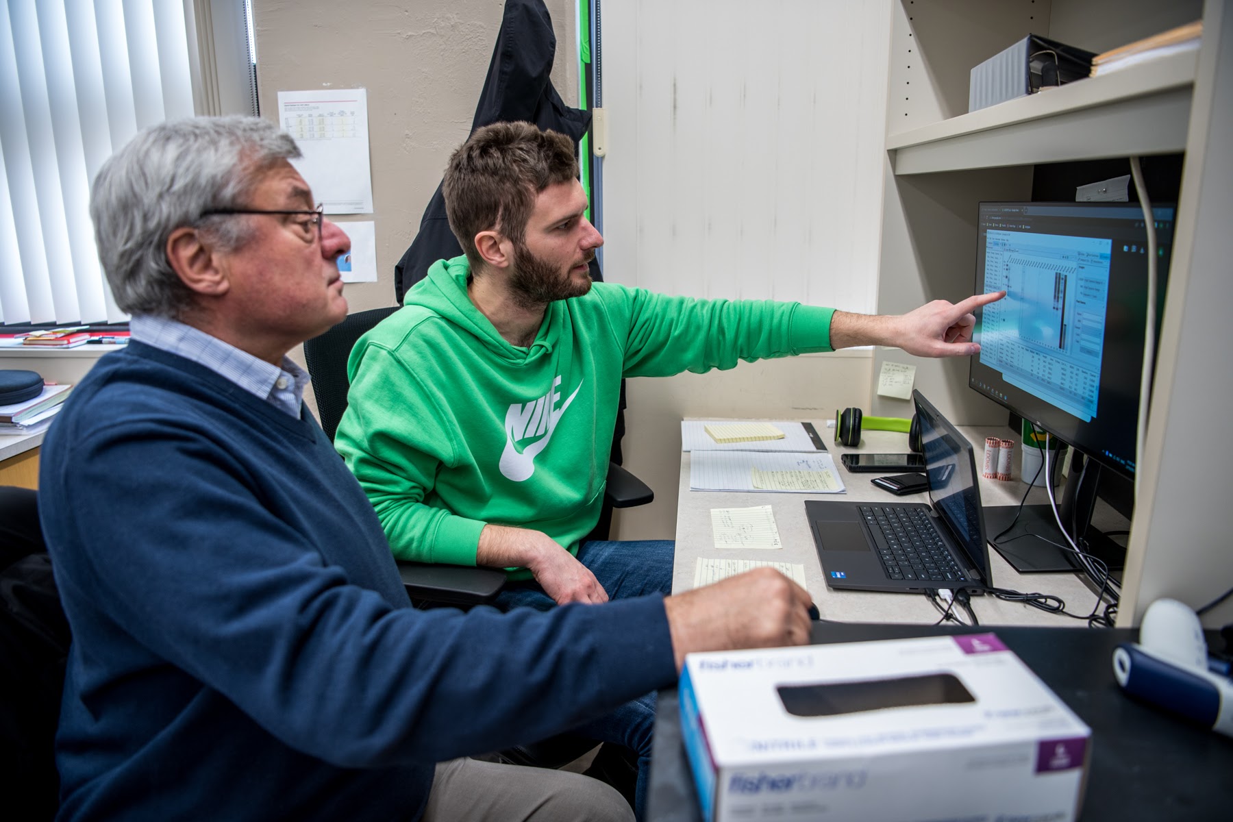 Postdoctoral research associate Alberto Caligiana (right) shows John Sedivy western blot data with results of ORF1 and ORF2 protein expression in senescent compared to young cells.