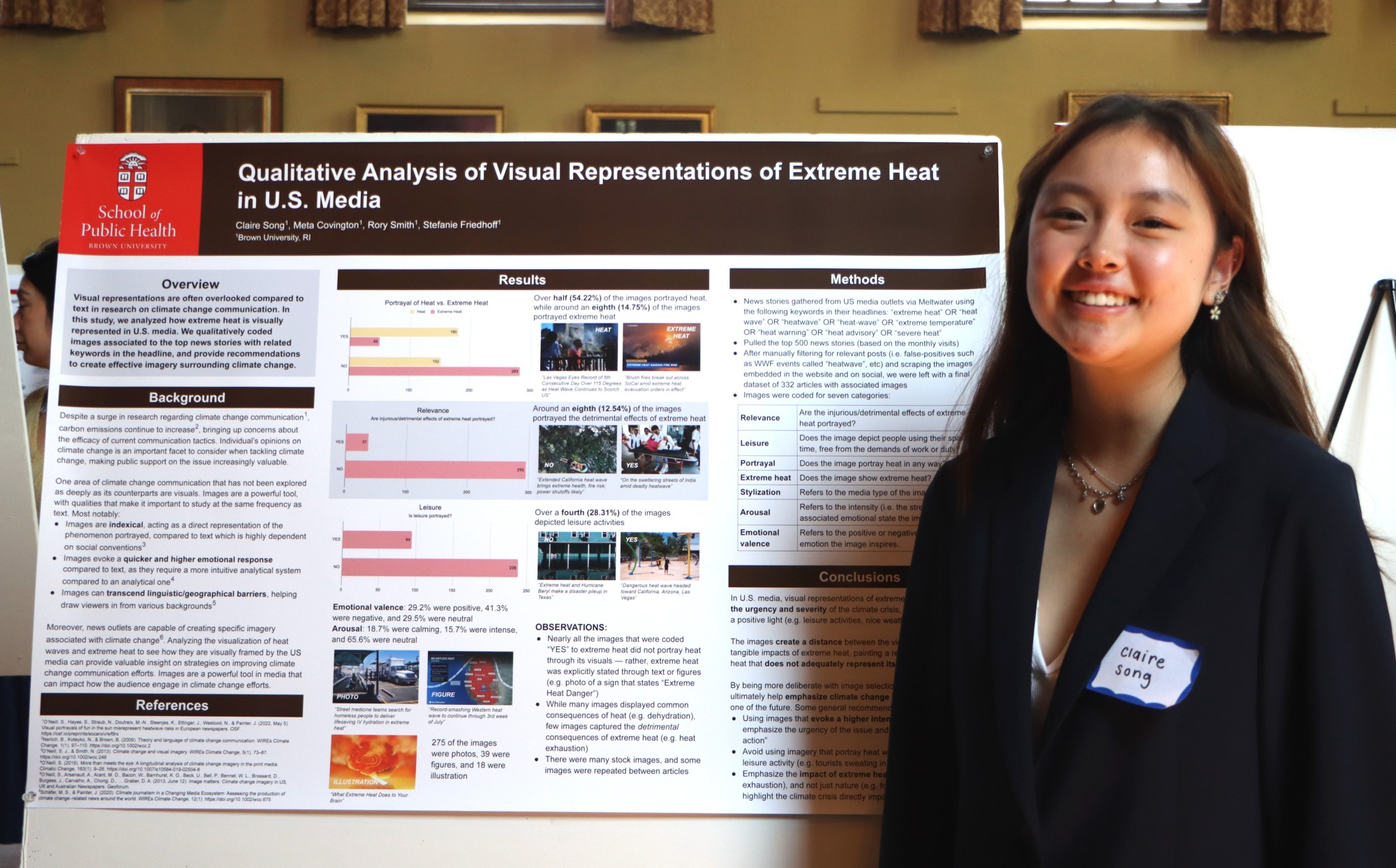 Female student researcher stands smiling next to her research poster that describes her study on visual representations of extreme heat in U.S. media.